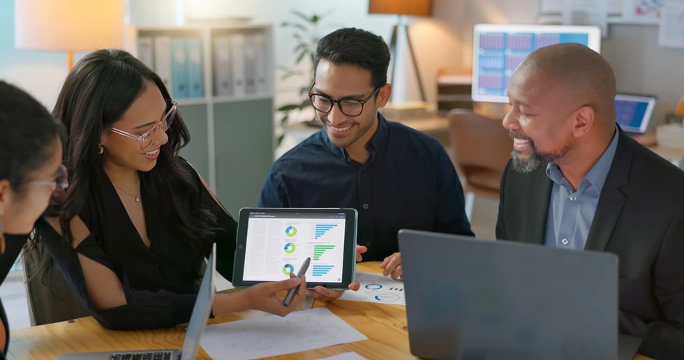 Equipo financiero revisando reportes de software cooperativo en tablet
